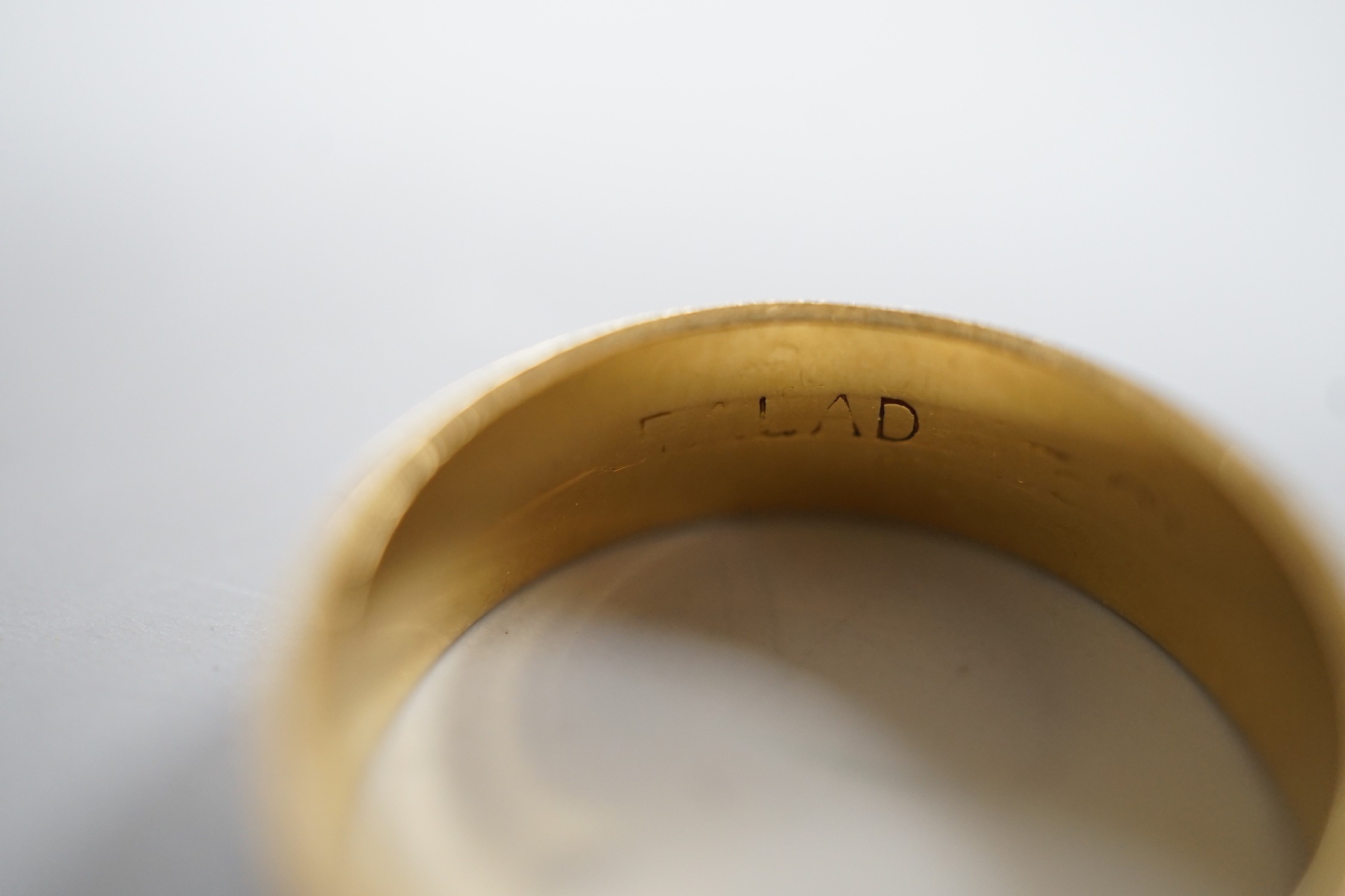 An engraved yellow and white metal band, size L, 3.7 grams.